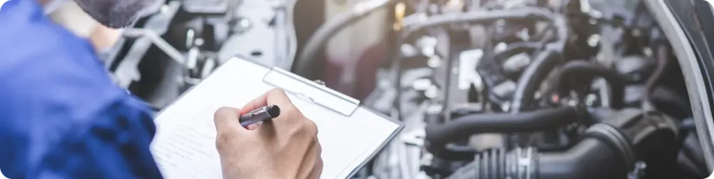 Emission & State Inspection In South Jordan, UT At Performance Place. Mechanic performing a vehicle inspections in auto repair shop.